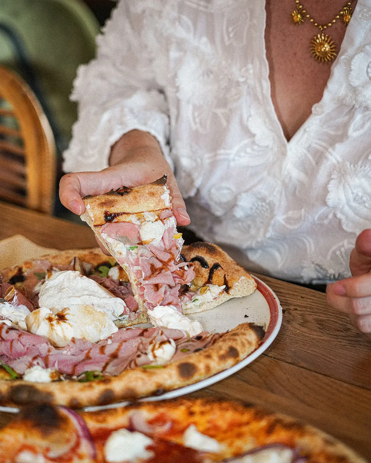 Une part de pizza à la mortadelle et stracciatella, crème de balsamique